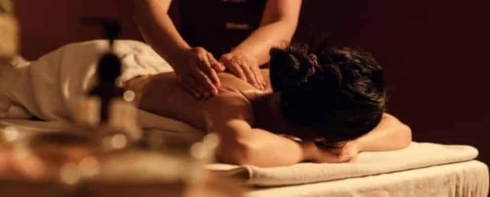 A person receiving a massage in a dimly lit room. 1