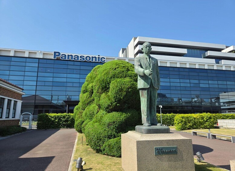 A statue in front of a Panasonic building. 1