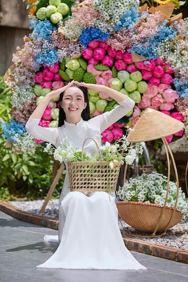 A person in a white dress holding a basket of flowers, with a colorful floral arrangement in the background. 3