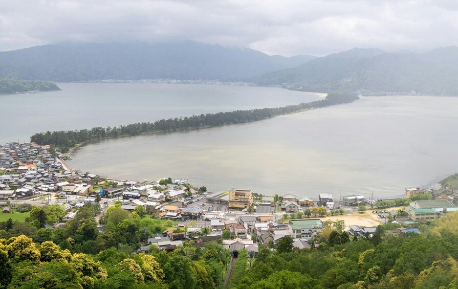 A coastal town with a bay, surrounded by mountains and dense greenery. 4