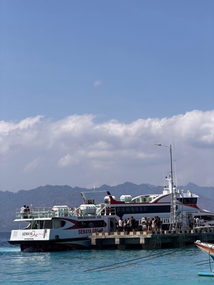 A ferry named 'SEMAYA One' docked at a pier with mountains in the background. 5