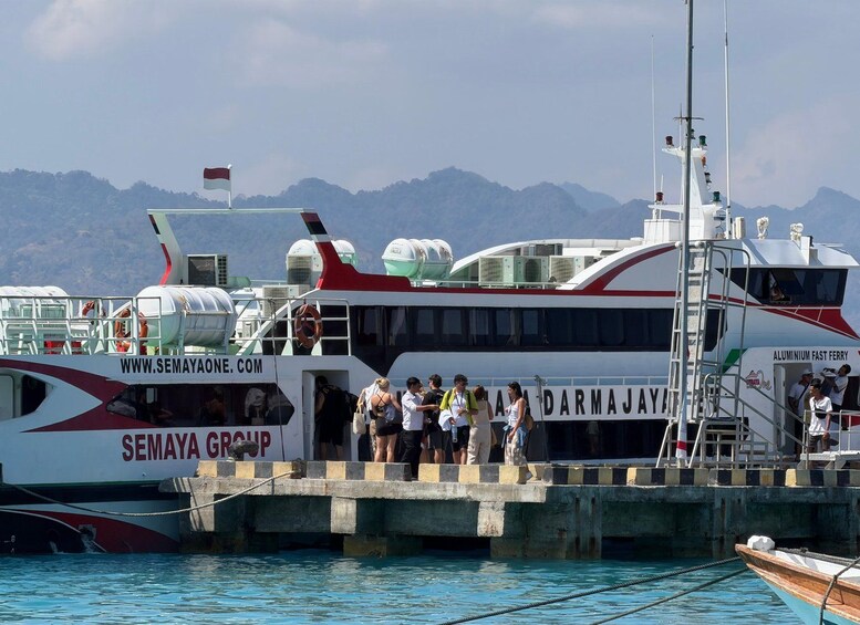 A ferry docked at a pier with passengers boarding. 3
