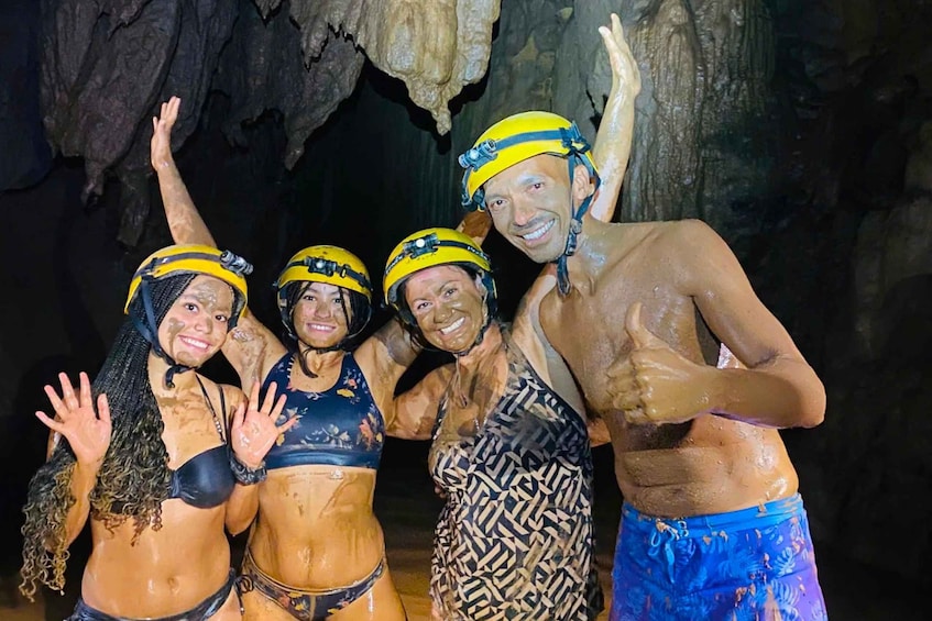 A group of people in a cave with helmets and mud on their bodies. 3