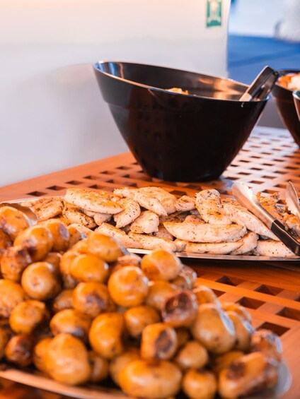 A wooden table with grilled chicken and roasted mushrooms. 3