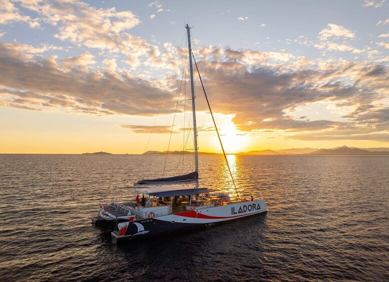 A sailboat named ILADORA on calm waters during sunset. 2