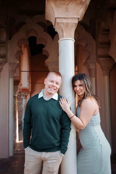 A man and a woman standing in an architectural corridor with arches and columns. 5