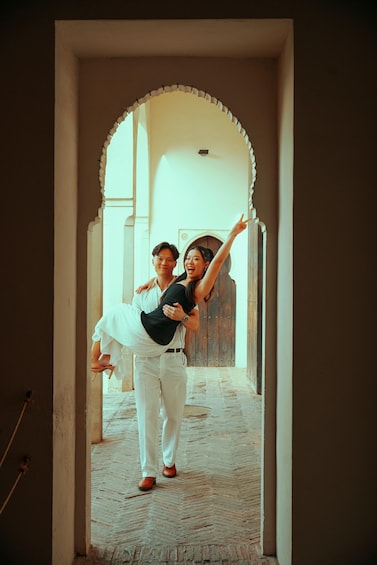 A person carrying another through a corridor with an arched doorway. 1