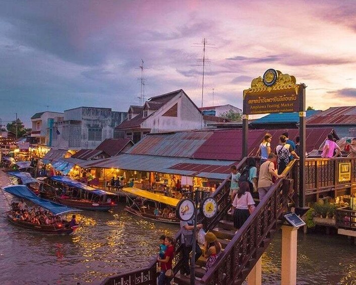 A riverside market with boats and people. 5