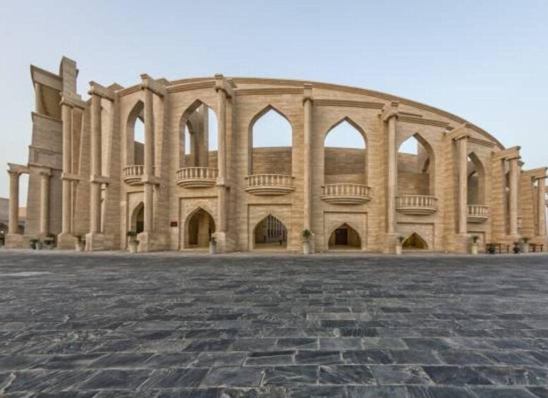A large, historic stone structure with arches and columns, likely a former theater or amphitheater. 3