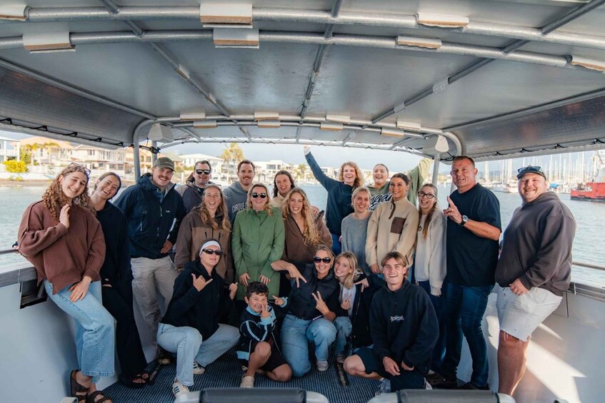 A group of people on a boat with a marina in the background. 2