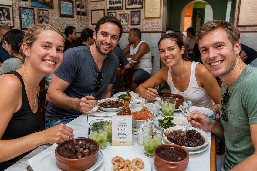 A group of people dining at a restaurant with various dishes and drinks on the table. 2
