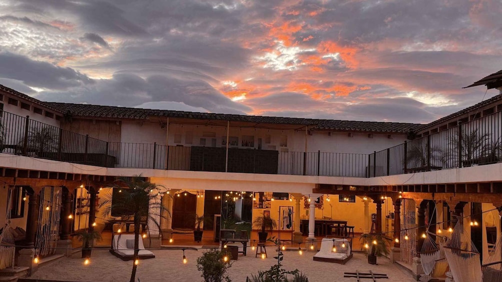 A courtyard with a traditional building, outdoor seating, and string lights. 4