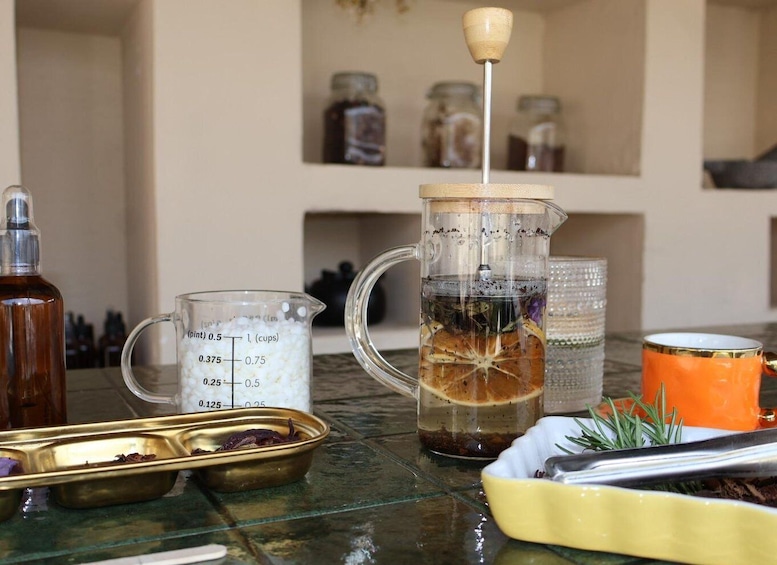 A kitchen with a tea infuser, measuring cups, and a mug. 5