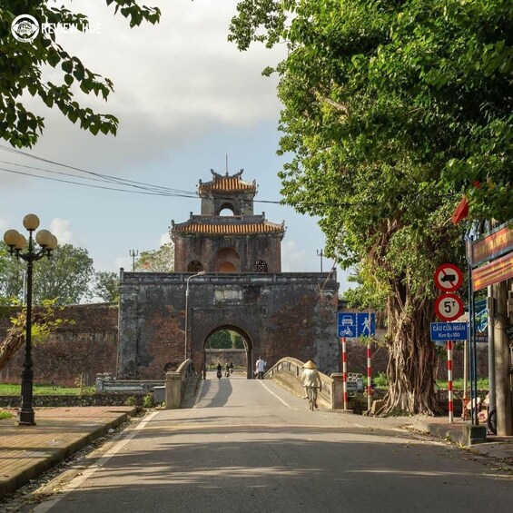 An ancient gate with traditional architecture, a clear sky, and a sign indicating a 5-ton vehicle limit. 4
