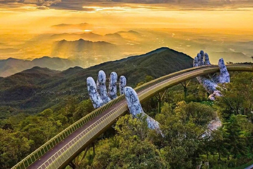 A bridge with a unique hand-shaped design, surrounded by lush greenery and mountains. 5