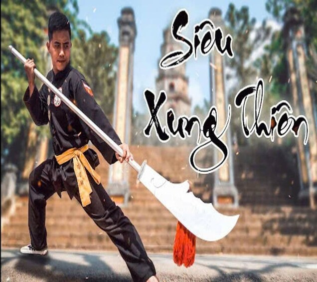 A person in traditional martial arts attire holding a weapon, with temple structures in the background. 3