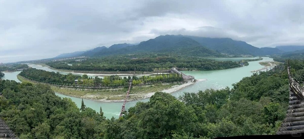 A river winding through a mountainous landscape with a bridge and a dam. 3