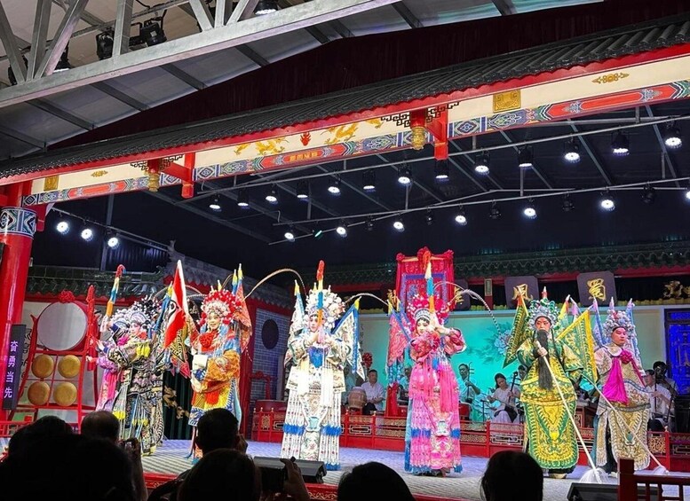 A traditional Chinese opera performance with performers in elaborate costumes and masks. 4