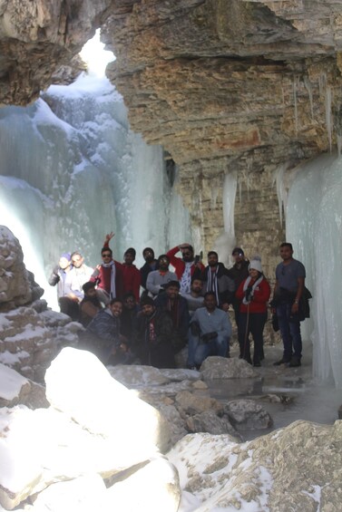 A group of people inside a cave with ice formations. 5