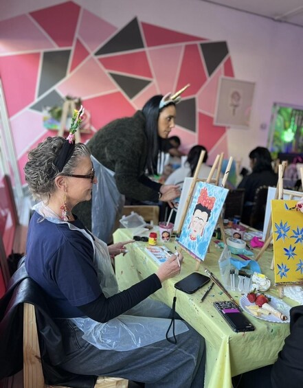 A person painting a portrait on a canvas. 3