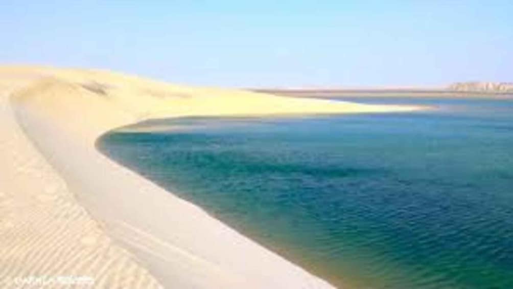 A coastal landscape with a sandy beach and calm sea. 5
