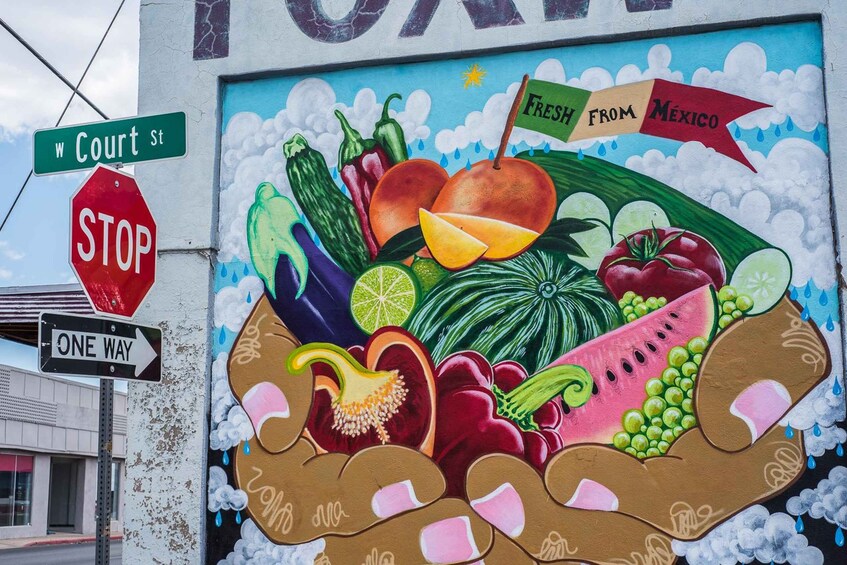 A mural of fresh produce with a 'STOP' sign and street signs. 2