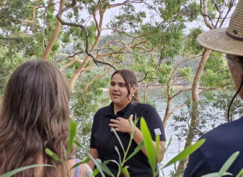 A group of people standing outdoors near a body of water, surrounded by trees. 4