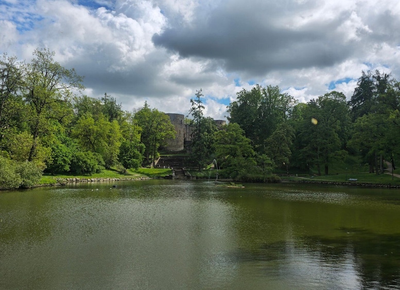 A calm lake surrounded by lush greenery and a historic castle in the background. 3