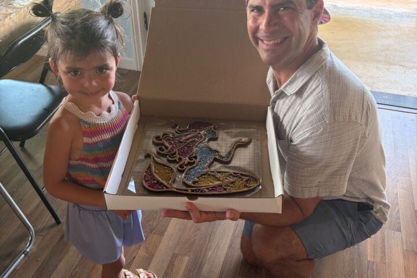A person holding a pizza box with a child beside them. 5