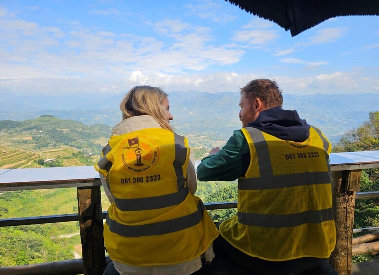 Two people in yellow safety vests with reflective stripes, overlooking a mountainous landscape. 3