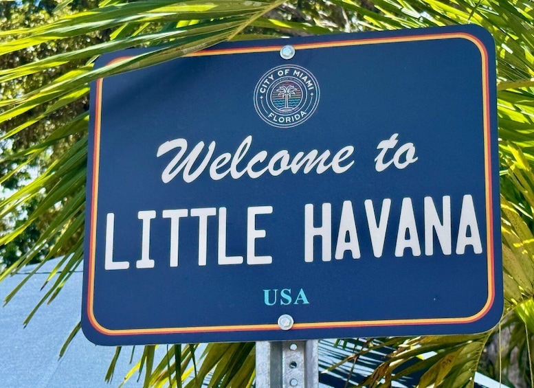 A welcome sign for Little Havana, USA, with palm leaves in the background. 5