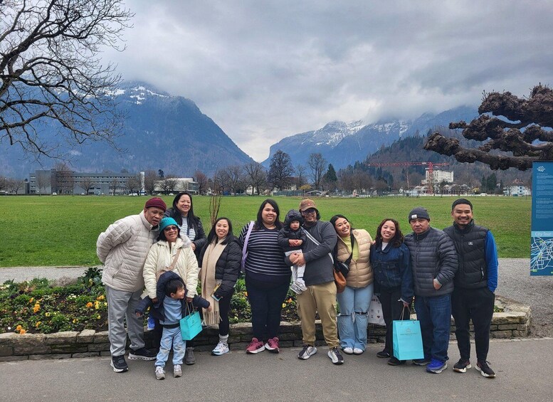 A group of people posing in a park with mountains in the background. 4