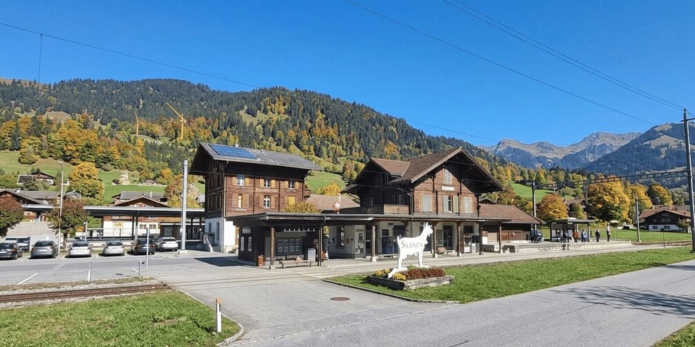 A train station with a mountain backdrop, a solar panel on the roof, and a sign reading 'SLANEX.' 5