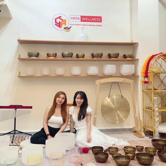 Two people in a wellness center with meditation bowls and a gong. 2
