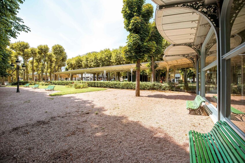 A covered outdoor area with benches and trees. 2