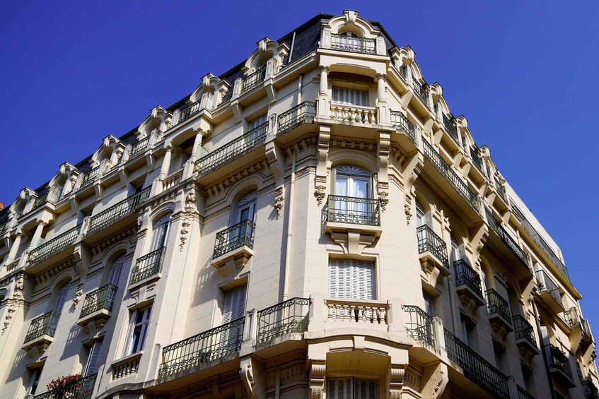 A multi-story building with ornate balconies and classical architectural details. 5