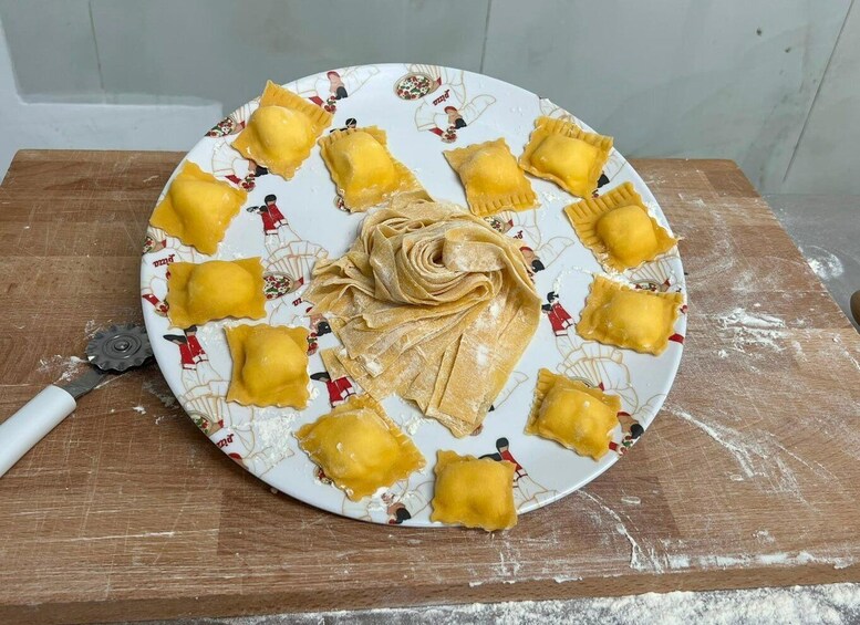 A plate of ravioli and a pasta cutter on a wooden surface. 3