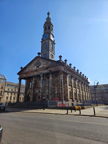 A historic building with a clock tower, columns, and a dome. 2