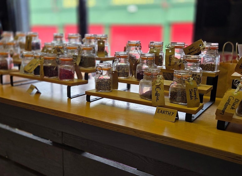 A display of various spices and herbs in glass jars with labels, arranged on wooden stands. 5