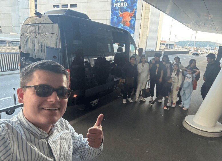 Ryhmä ihmisiä nousee kyytiin mustaan bussiin, jonka takana näkyy suuri mainos, jossa on teksti ”THE HERD”. 5