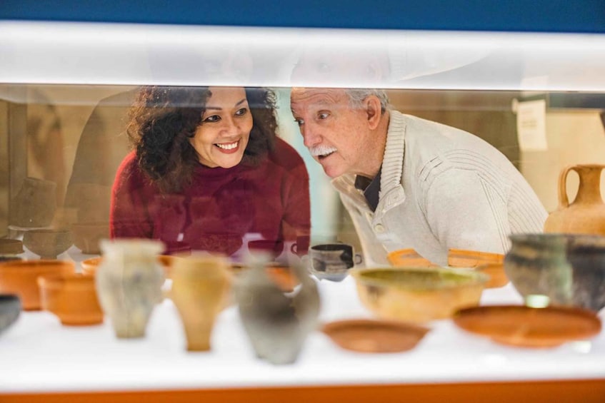 A couple looking at pottery displayed in a shop window. 1
