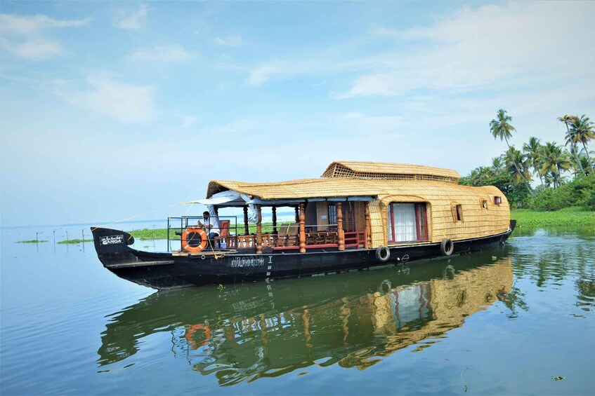 A houseboat with a thatched roof, a covered deck, and a motor. 1