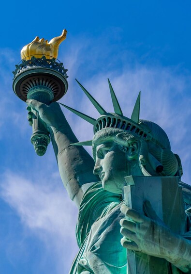 The Statue of Liberty holding a torch with a crown on top. 1