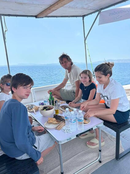 A group of people dining on a boat with a view of the sea. 1