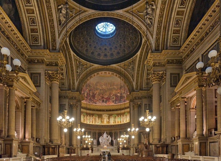 An ornate interior with a large dome, columns, and chandeliers. 1