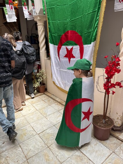A person in a green cap and a flag with a red star and crescent. 2
