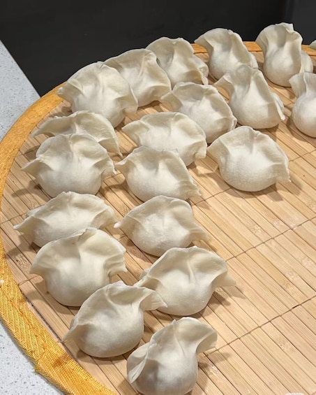 A wooden tray with several dumplings arranged on it. 2