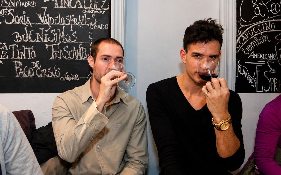 Two men sitting and drinking wine. 3