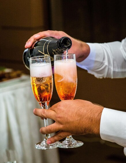 A person pouring a drink into a glass. 2