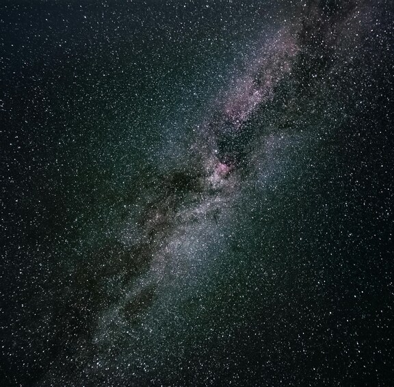 A starry night sky with a dense cluster of stars and a visible galaxy. 5